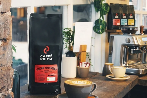bags of caffe prima coffee beans next to sage coffee machine